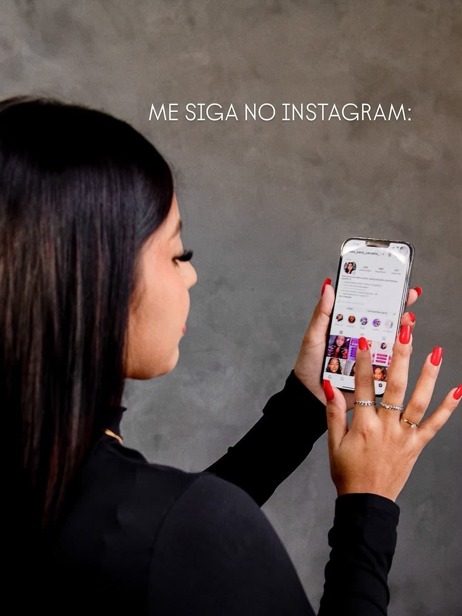 Karol olhando o próprio perfil do Instagram no celular